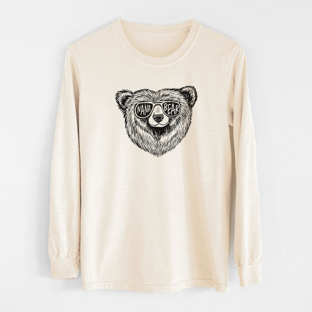 Ivory Comfort Colors long sleeve shirt laid flat, printed with a black ink bear's face wearing sunglasses that read Nana Bear.