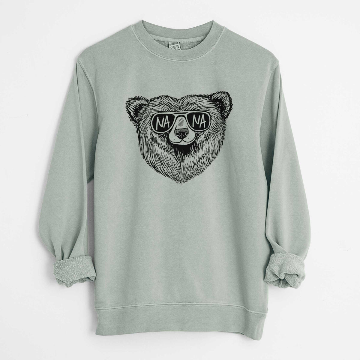 Sage green pigment dyed crewneck sweatshirt laid flat with the sleeves rolled, printed with a black ink bear's face wearing sunglasses that read Nana.