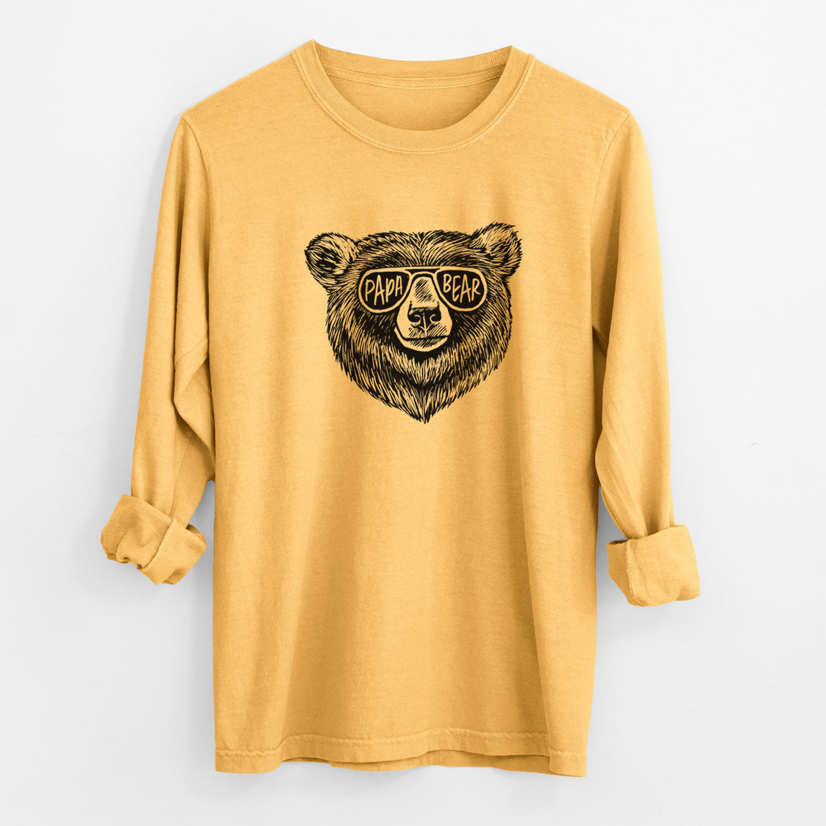 Golden wheat yellow Comfort Colors long sleeve shirt laid flat with the cuffs rolled, printed with a black ink bear's face wearing sunglasses that read Papa Bear.