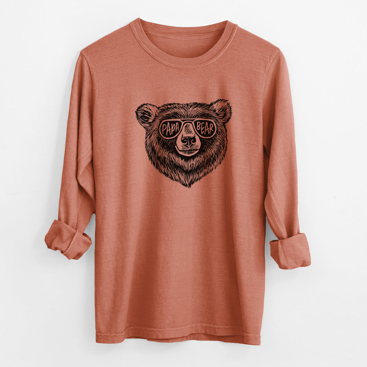 Yam burnt orange Comfort Colors long sleeve shirt laid flat with the cuffs rolled, printed with a black ink bear's face wearing sunglasses that read Papa Bear.