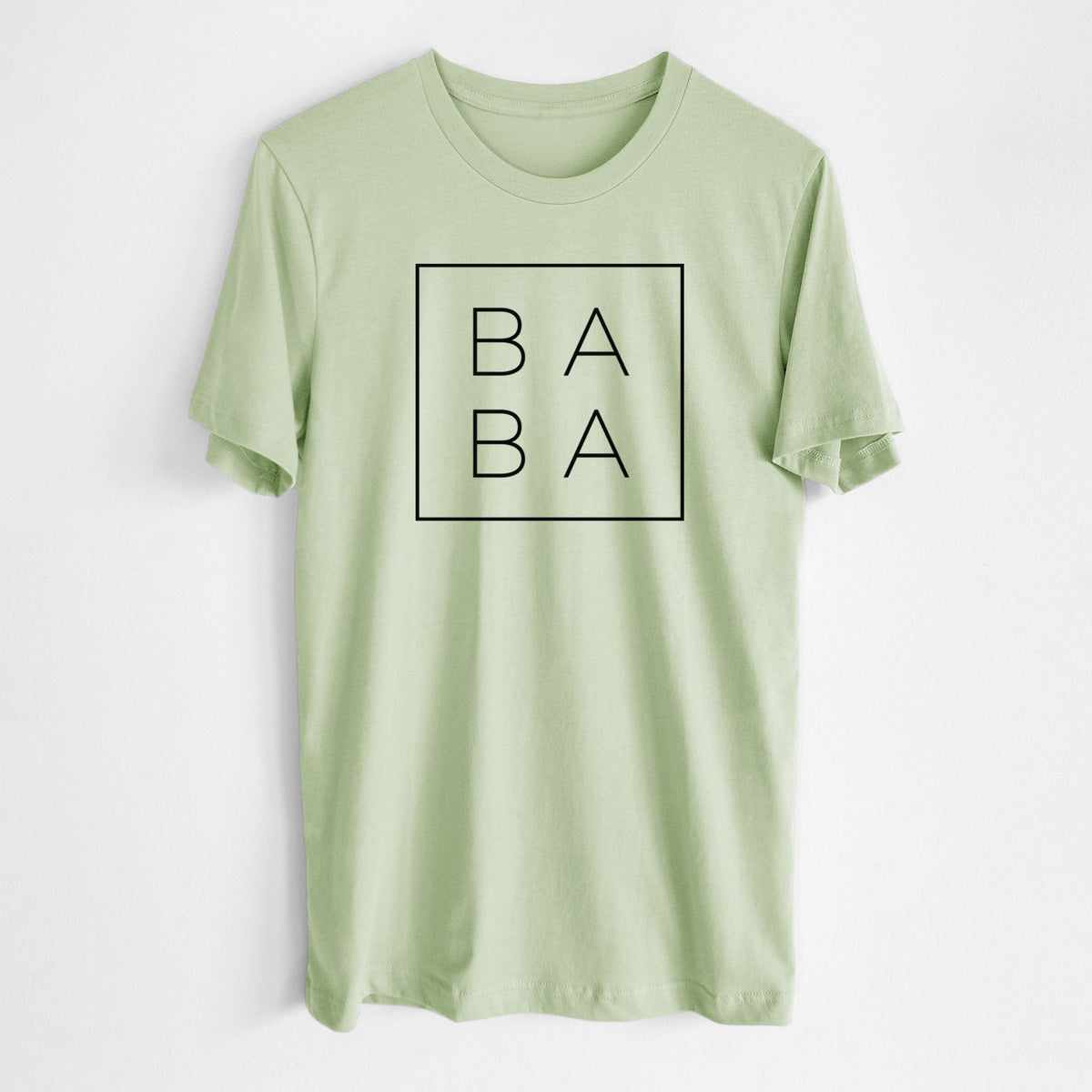 Spring green lightweight cotton t-shirt laid flat, printed with the word BABA in thin black letters stacked inside a square outline.
