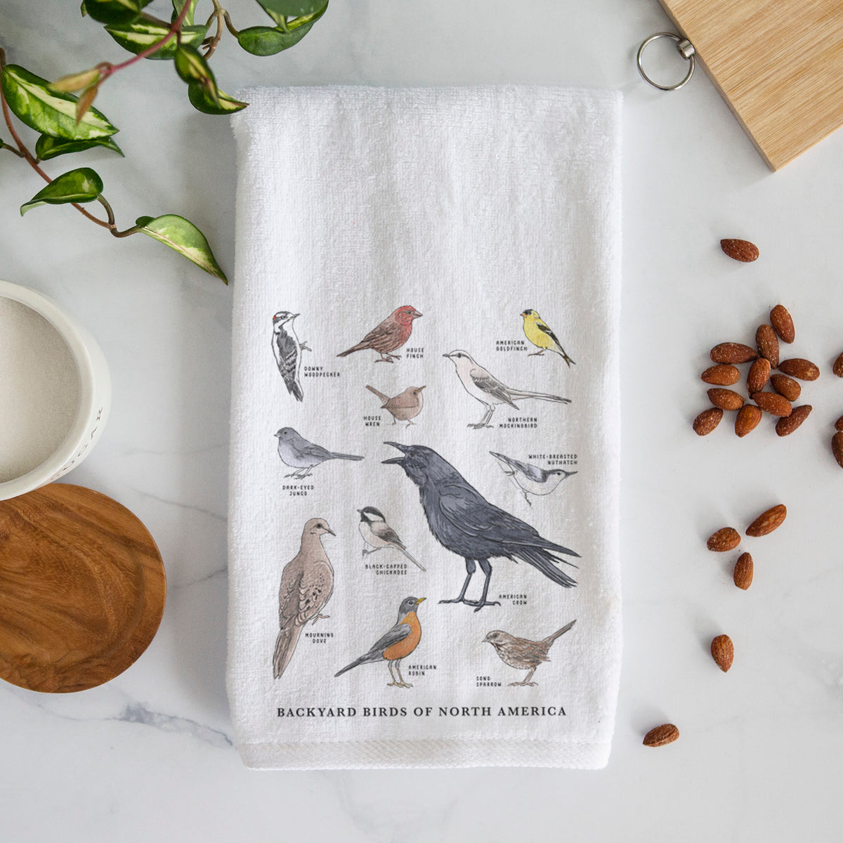 White hand towel printed with a full-color chart of North American backyard birds, each labeled with its species.