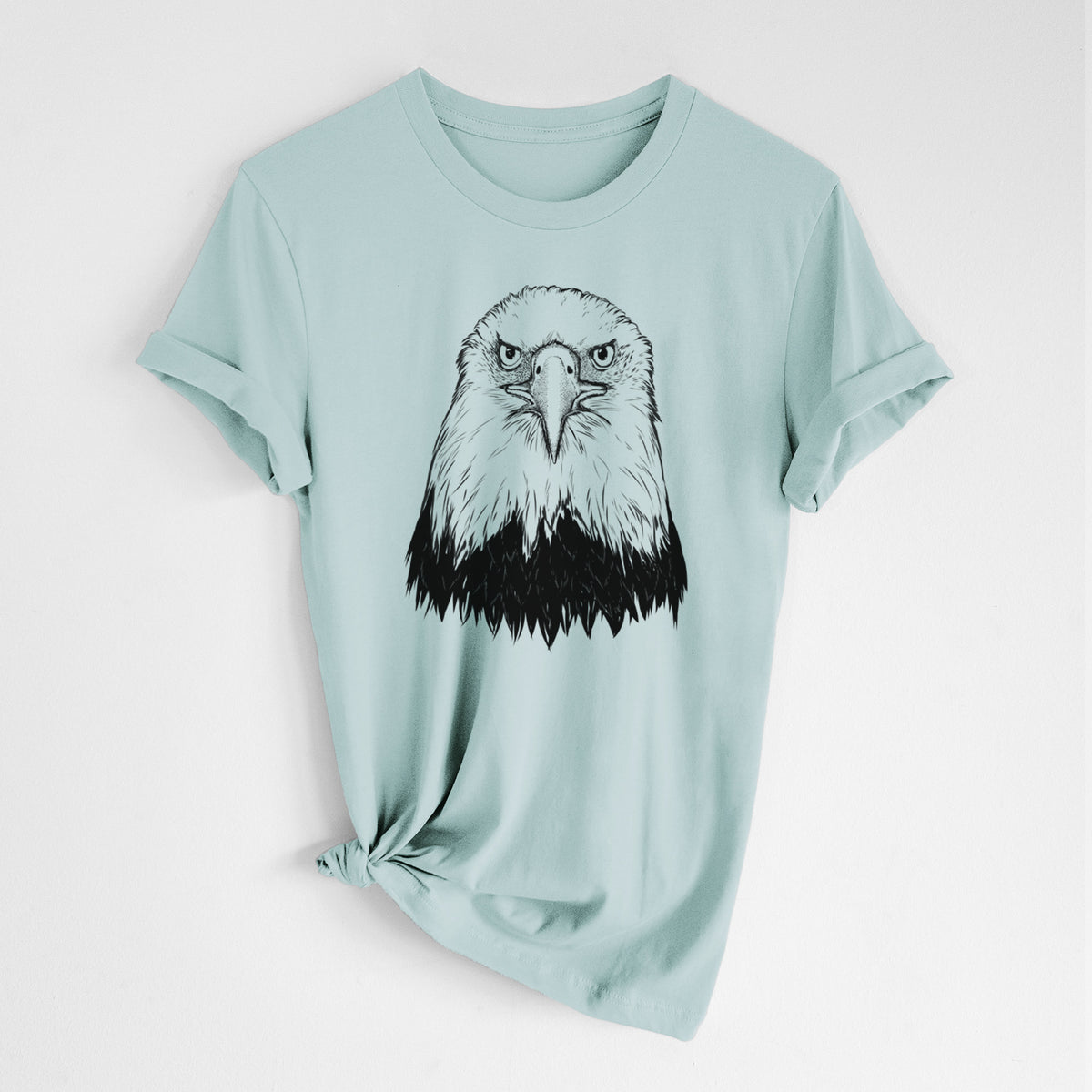 Dusty blue lightweight cotton t-shirt laid flat with the sleeves rolled, printed with a detailed black ink portrait of a bald eagle facing forward.