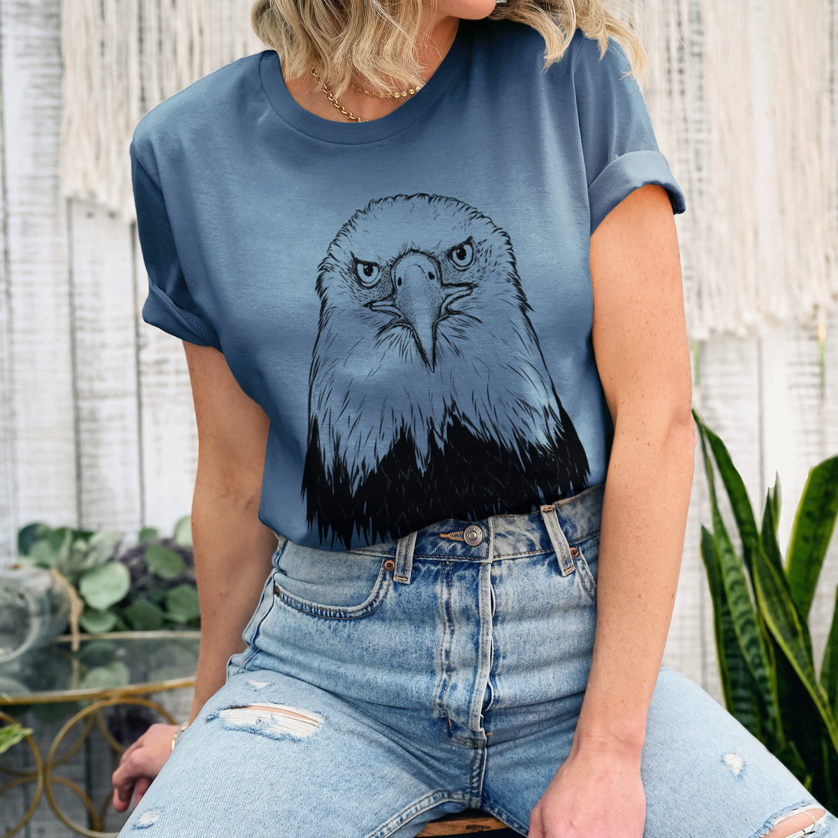 Woman wearing a steel blue lightweight cotton t-shirt printed with a detailed black ink portrait of a bald eagle facing forward.