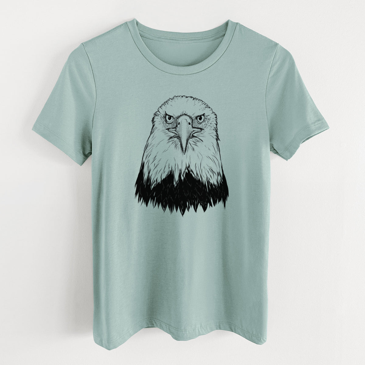 Dusty blue women's relaxed fit cotton t-shirt laid flat, printed with a detailed black ink portrait of a bald eagle facing forward.