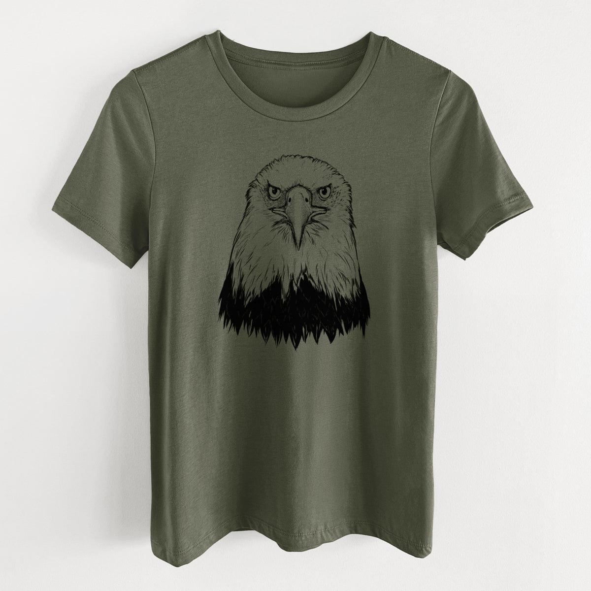 Military green women's relaxed fit cotton t-shirt laid flat, printed with a detailed black ink portrait of a bald eagle facing forward.