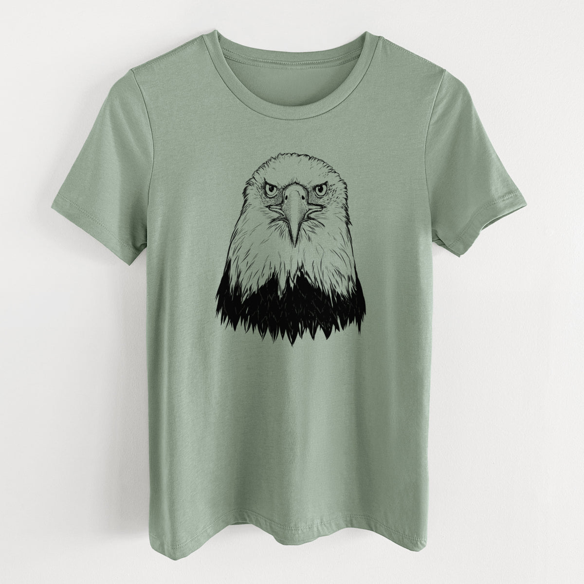 Sage green women's relaxed fit cotton t-shirt laid flat, printed with a detailed black ink portrait of a bald eagle facing forward.