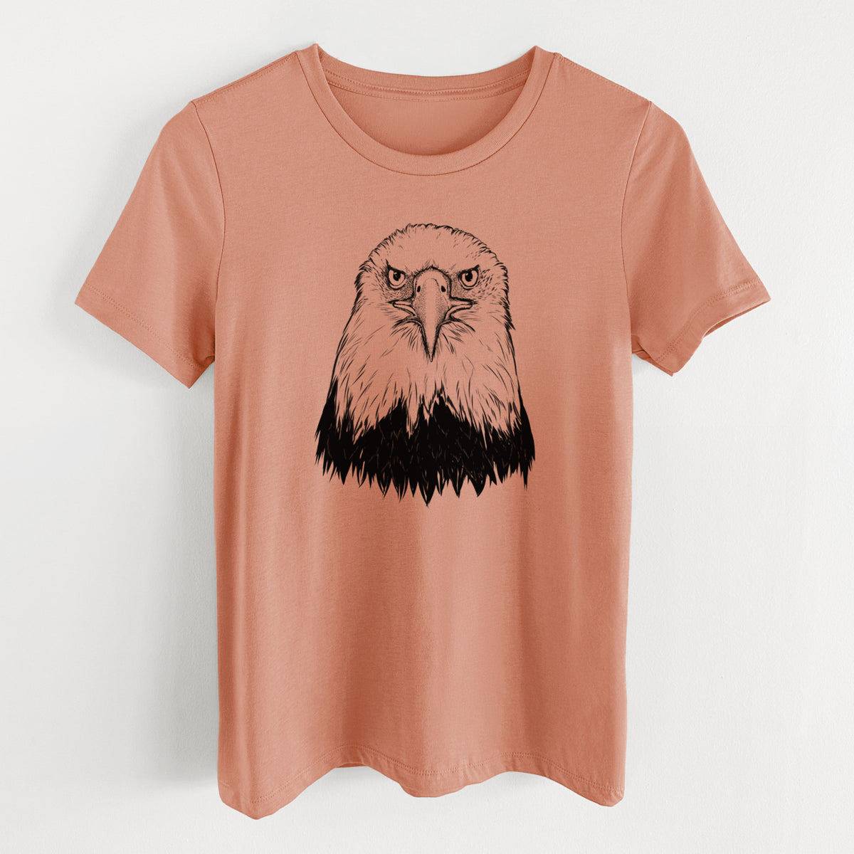 Terracotta orange women's relaxed fit cotton t-shirt laid flat, printed with a detailed black ink portrait of a bald eagle facing forward.