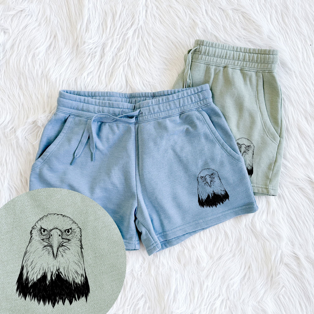 Two pairs of Cali Wave shorts in different colors printed with a detailed black ink portrait of a bald eagle facing forward, with a close-up of the print.