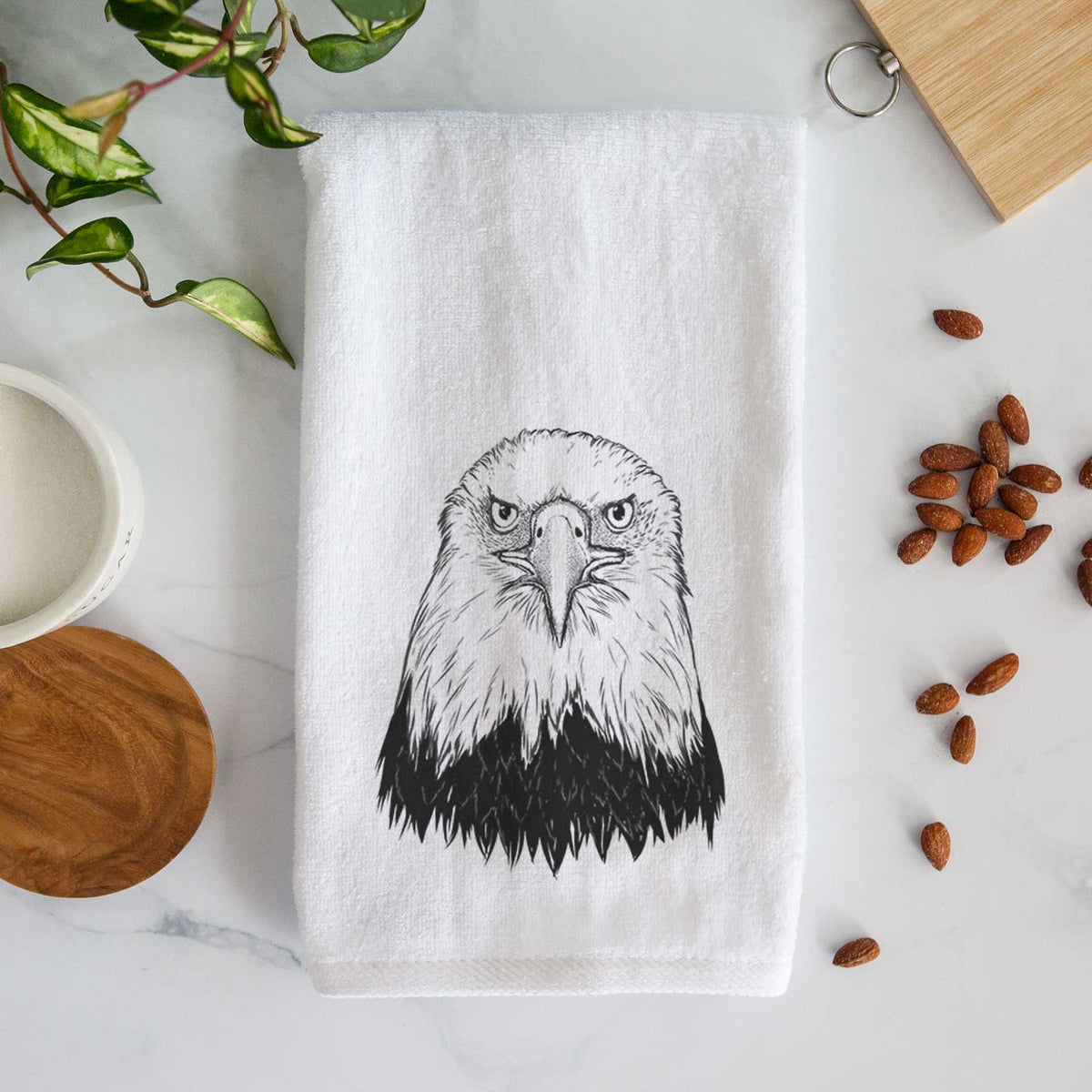 White hand towel printed with a detailed black ink portrait of a bald eagle facing forward.