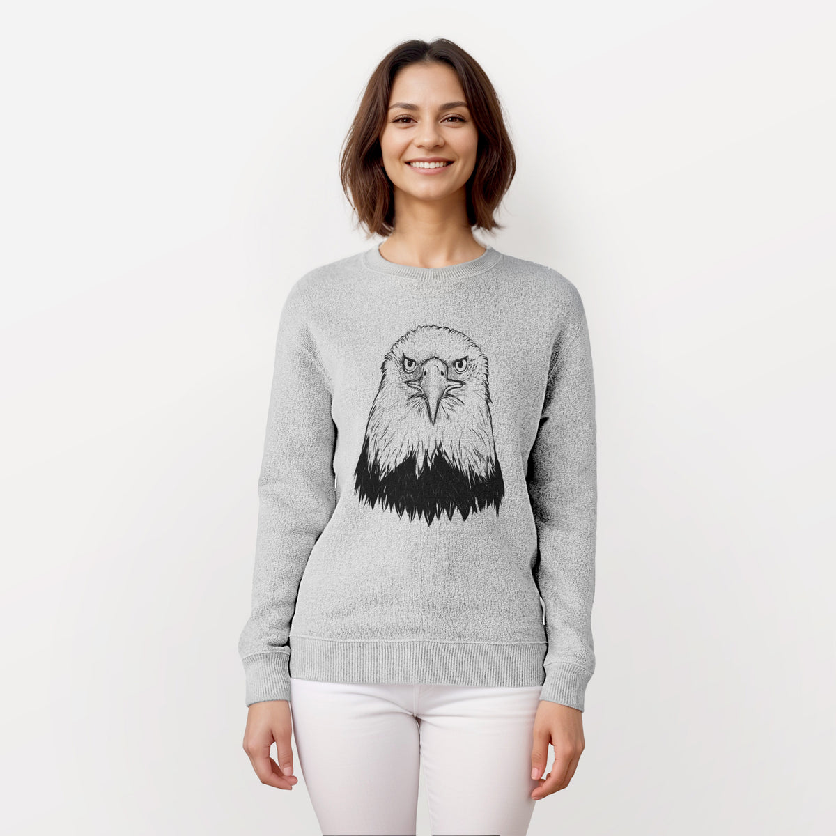 Woman wearing a knit sweatshirt printed with a detailed black ink portrait of a bald eagle facing forward.