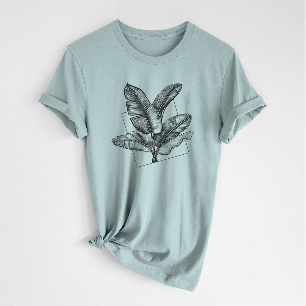 Dusty blue lightweight cotton t-shirt laid flat with the sleeves rolled, printed with a black ink illustration of banana leaves in front of a square outline.