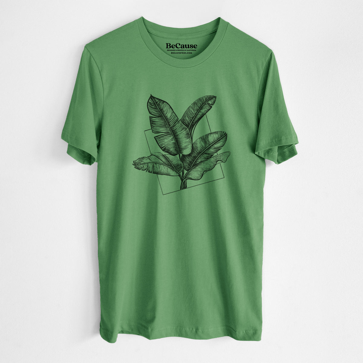 Leaf green lightweight cotton t-shirt laid flat, printed with a black ink illustration of banana leaves in front of a square outline.
