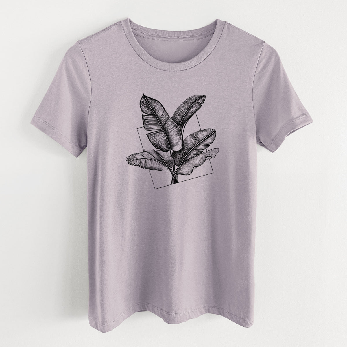 Light violet women's relaxed fit cotton t-shirt laid flat, printed with a black ink illustration of banana leaves in front of a square outline.