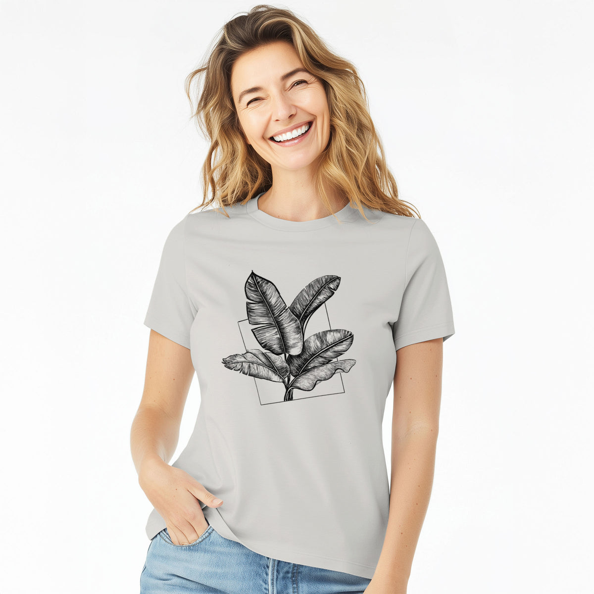 Woman wearing a lunar grey women's relaxed fit cotton t-shirt printed with a black ink illustration of banana leaves in front of a square outline.