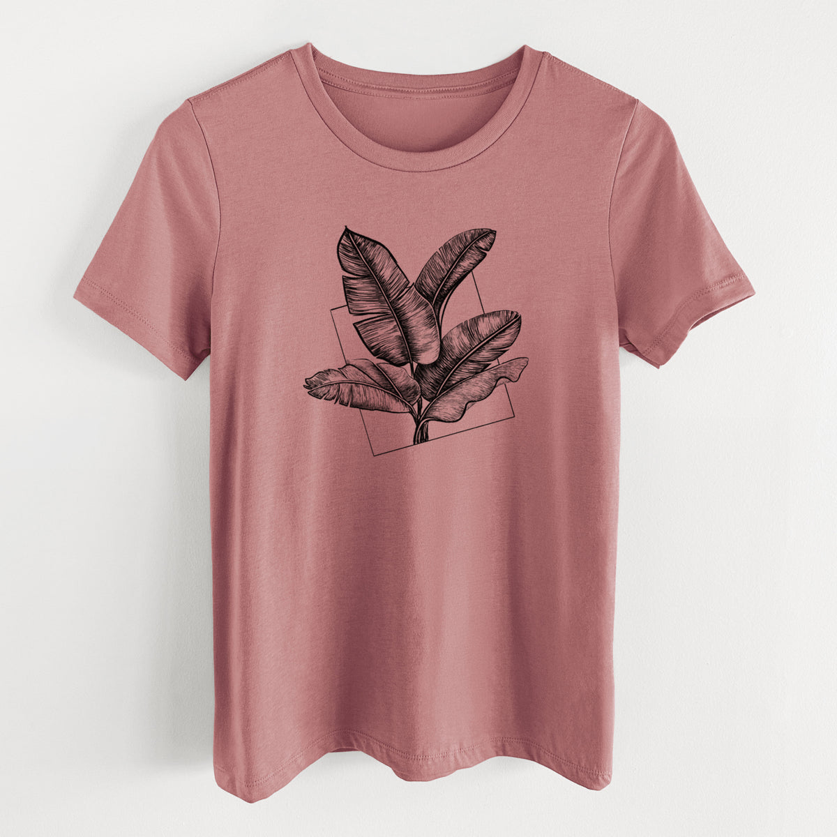 Mauve pink women's relaxed fit cotton t-shirt laid flat, printed with a black ink illustration of banana leaves in front of a square outline.