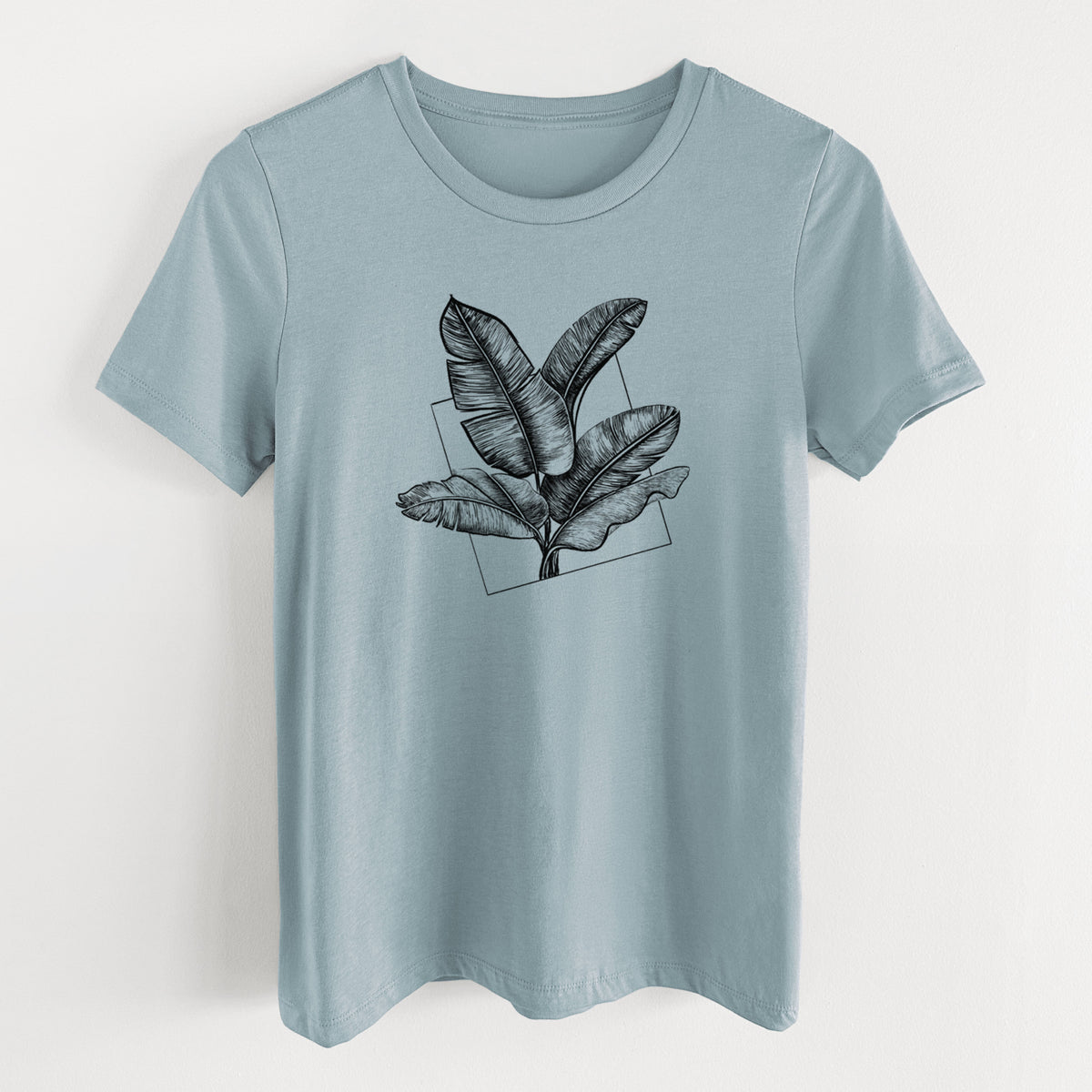 Vintage denim women's relaxed fit cotton t-shirt laid flat, printed with a black ink illustration of banana leaves in front of a square outline.