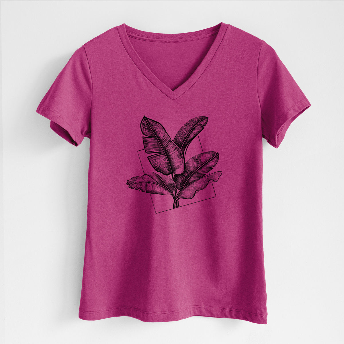 Berry pink women's relaxed fit cotton V-neck t-shirt laid flat, printed with a black ink illustration of banana leaves in front of a square outline.