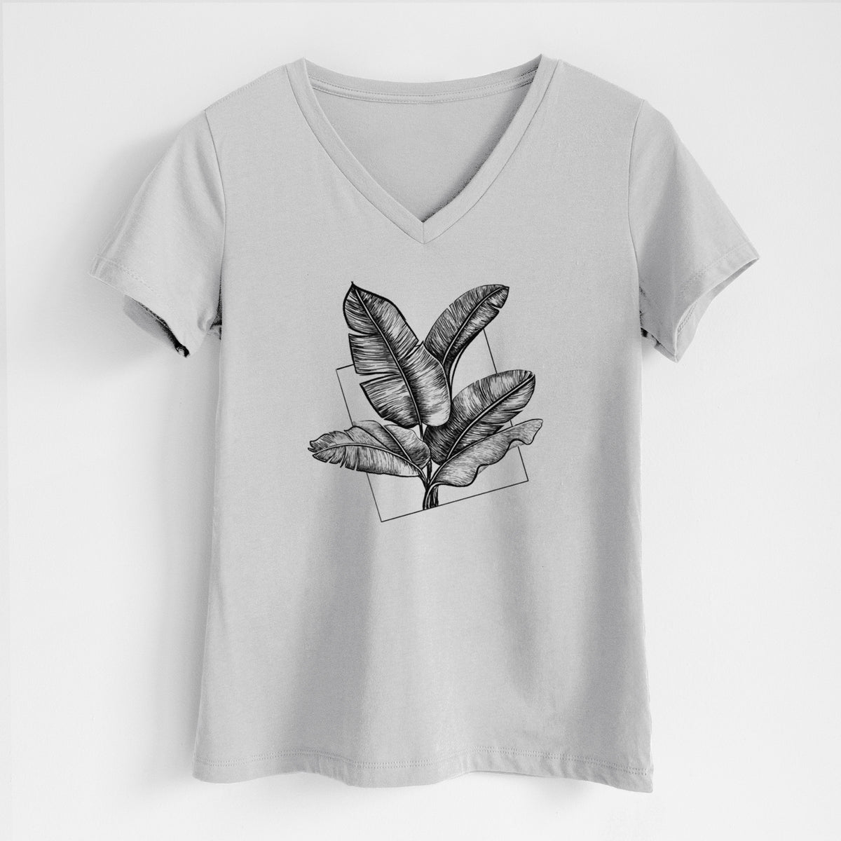 Lunar grey women's relaxed fit cotton V-neck t-shirt laid flat, printed with a black ink illustration of banana leaves in front of a square outline.