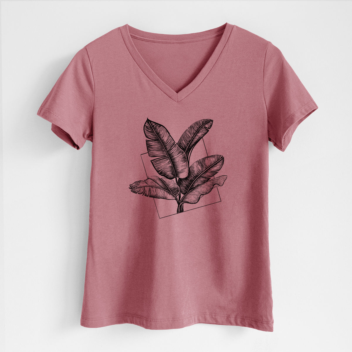 Mauve pink women's relaxed fit cotton V-neck t-shirt laid flat, printed with a black ink illustration of banana leaves in front of a square outline.