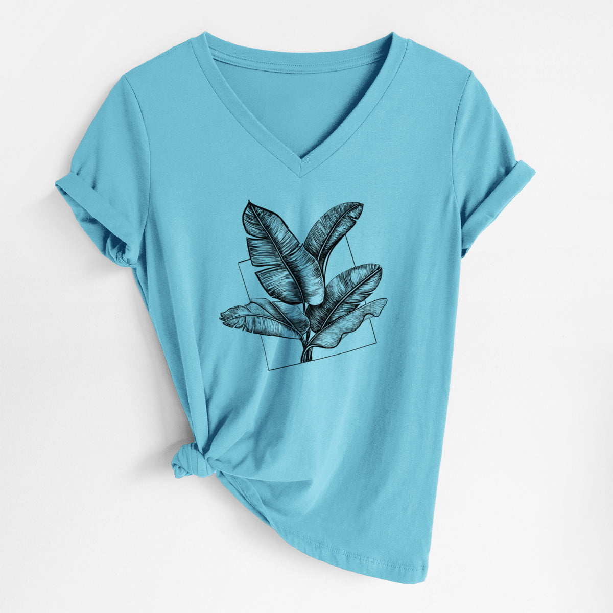 Turquoise women's relaxed fit cotton V-neck t-shirt laid flat, printed with a black ink illustration of banana leaves in front of a square outline.
