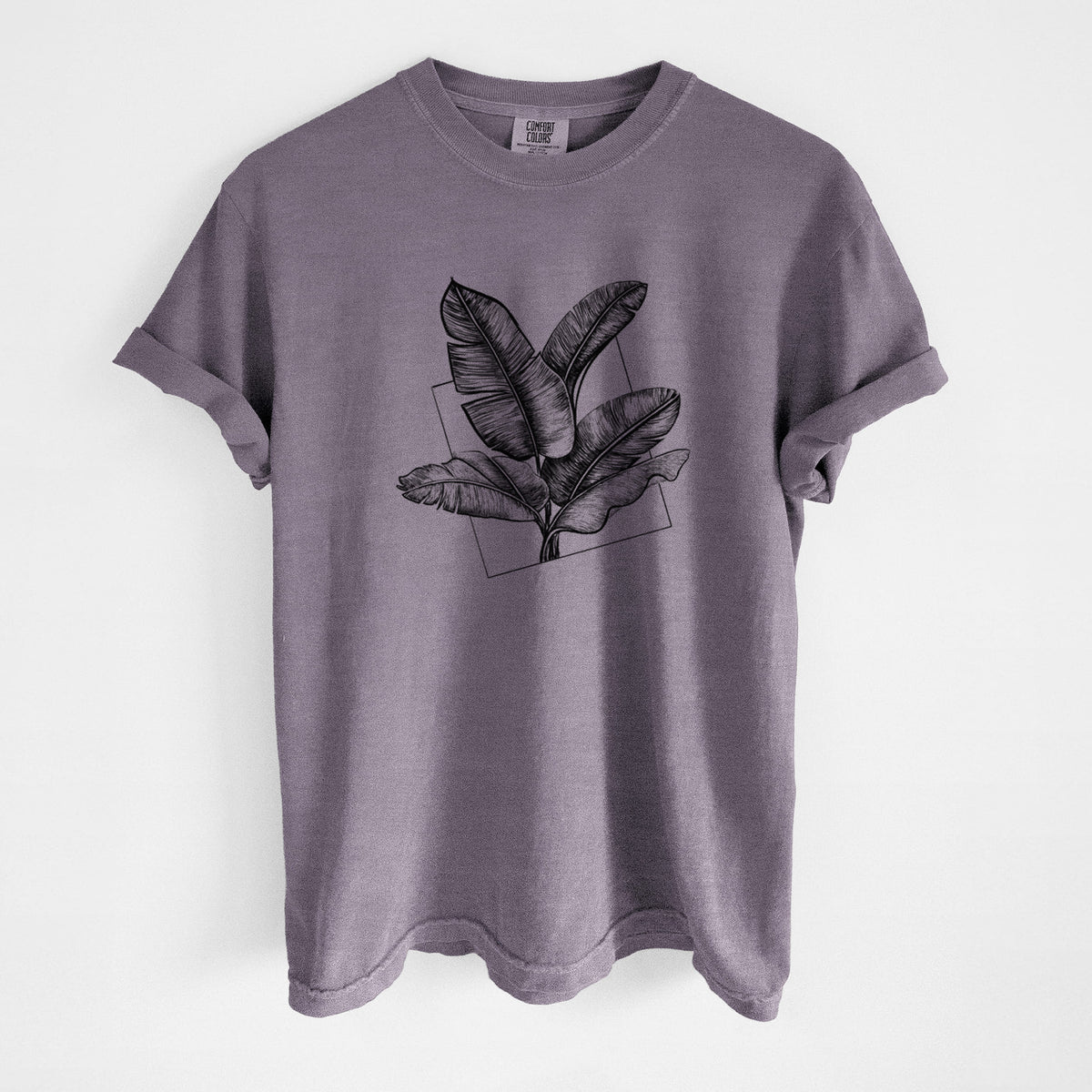 Wine red Comfort Colors t-shirt laid flat, printed with a black ink illustration of banana leaves in front of a square outline.