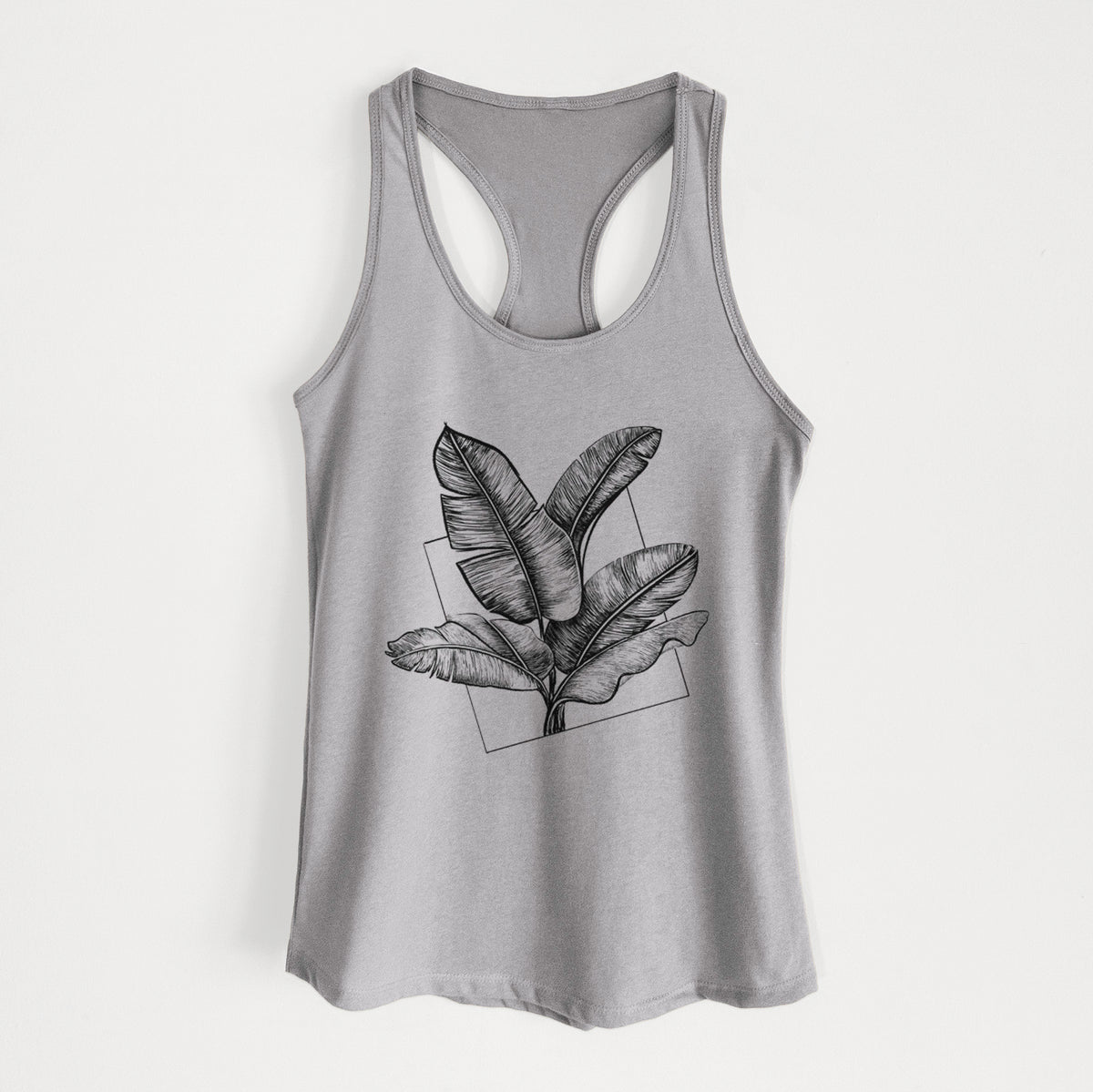 Heather grey women's racerback tank top laid flat, printed with a black ink illustration of banana leaves in front of a square outline.