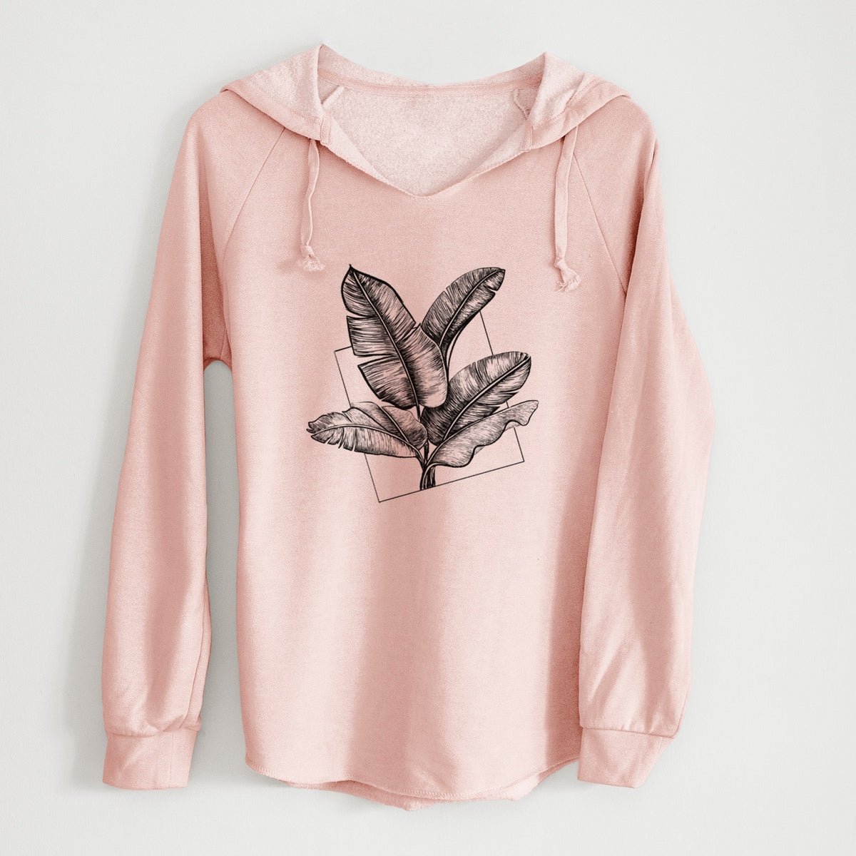 Blush pink women's Cali Wave hooded sweatshirt laid flat, printed with a black ink illustration of banana leaves in front of a square outline.