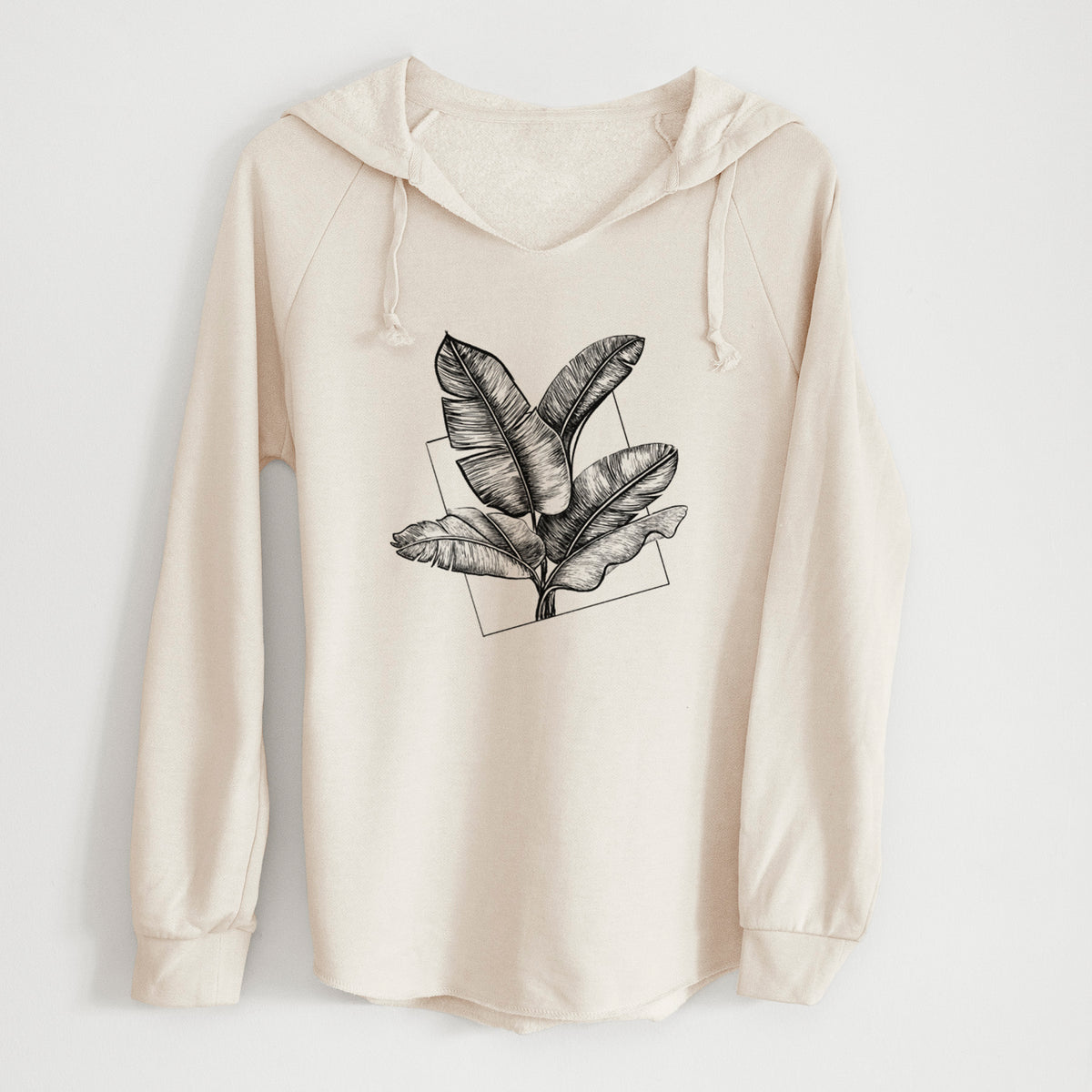 Bone cream women's Cali Wave hooded sweatshirt laid flat, printed with a black ink illustration of banana leaves in front of a square outline.
