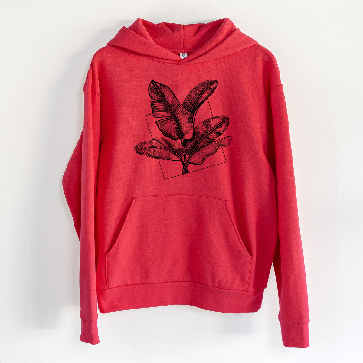 Banana Plant Leaves - Statement Midweight Hoodie in Cherry Red, hanging on a white wall, with a front kangaroo pocket and no drawcords.