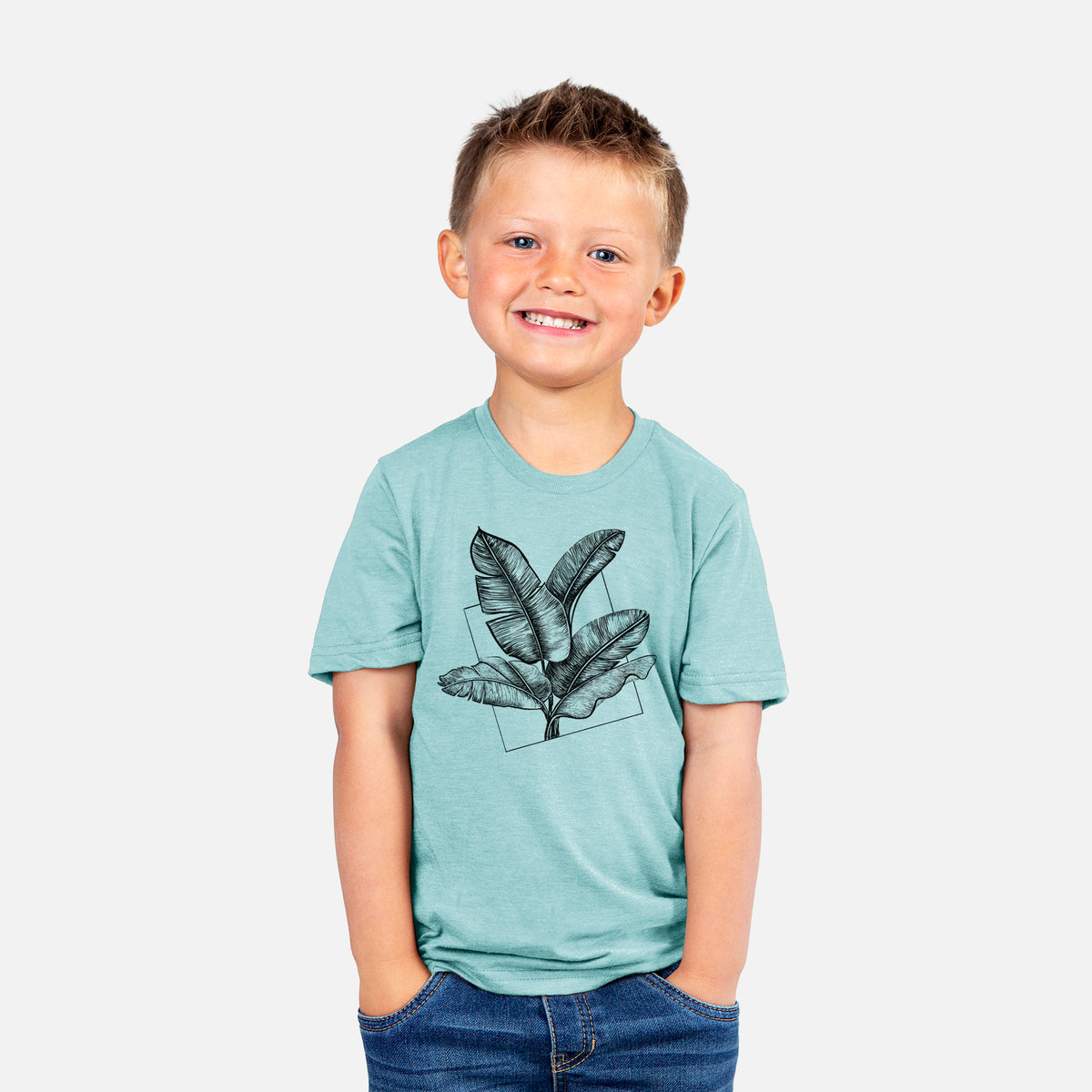 Smiling boy wearing a youth t-shirt printed with a black ink illustration of banana leaves in front of a square outline.