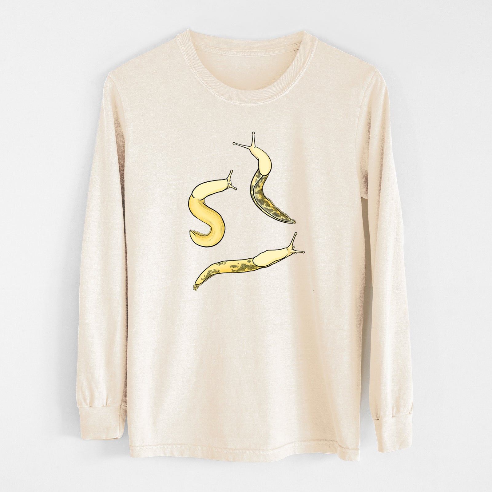 Ivory Comfort Colors long sleeve shirt laid flat, printed with a full-color illustration of three yellow banana slugs.