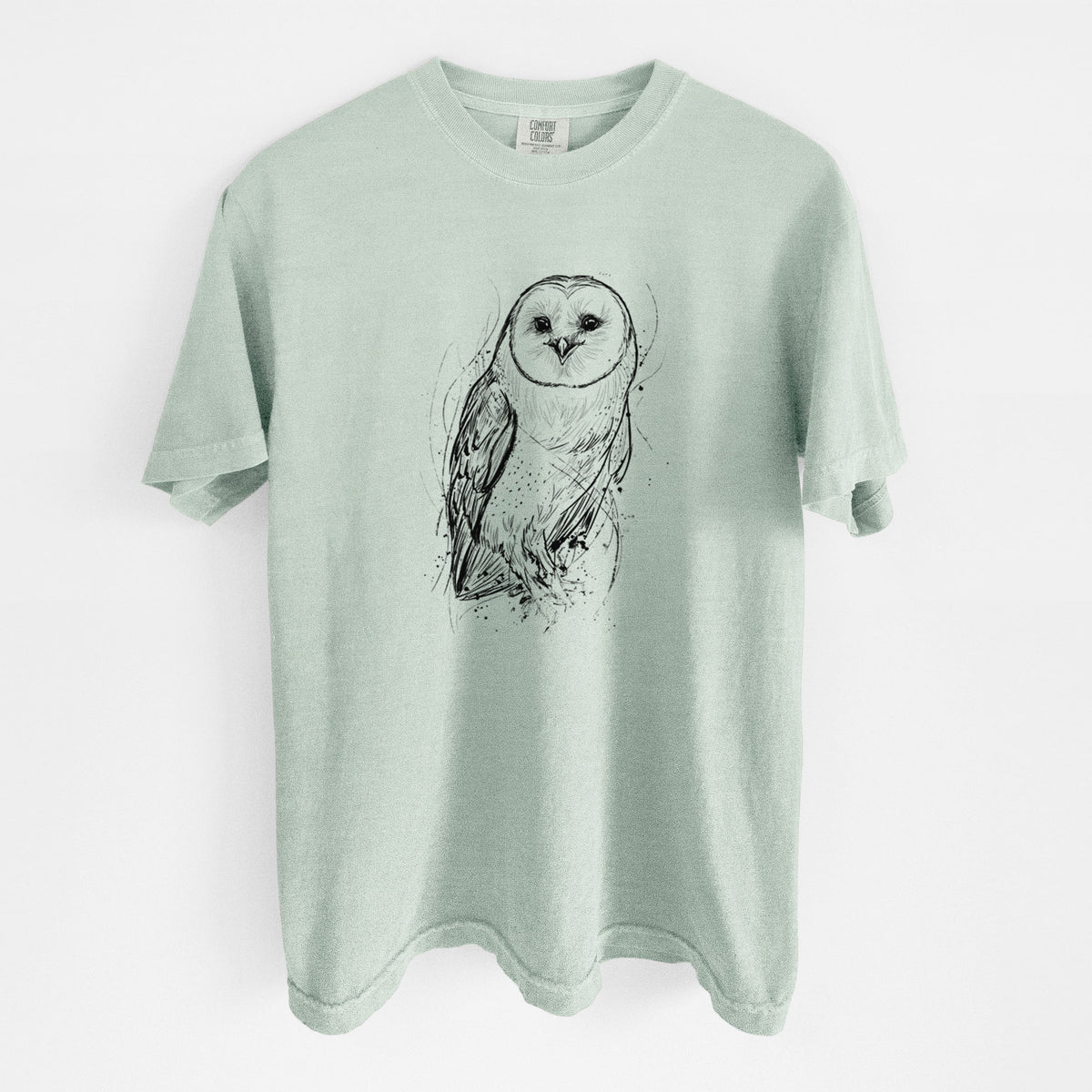 Bay green Comfort Colors t-shirt laid flat, printed with a detailed black ink illustration of a barn owl standing and facing forward.