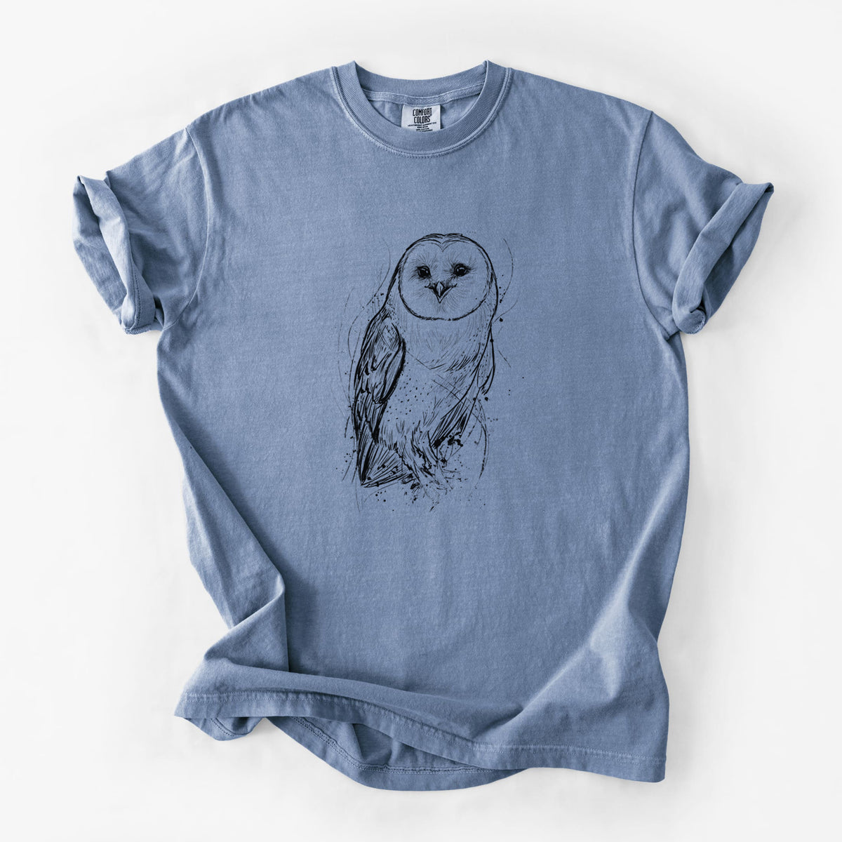 Blue jean Comfort Colors t-shirt laid flat, printed with a detailed black ink illustration of a barn owl standing and facing forward.