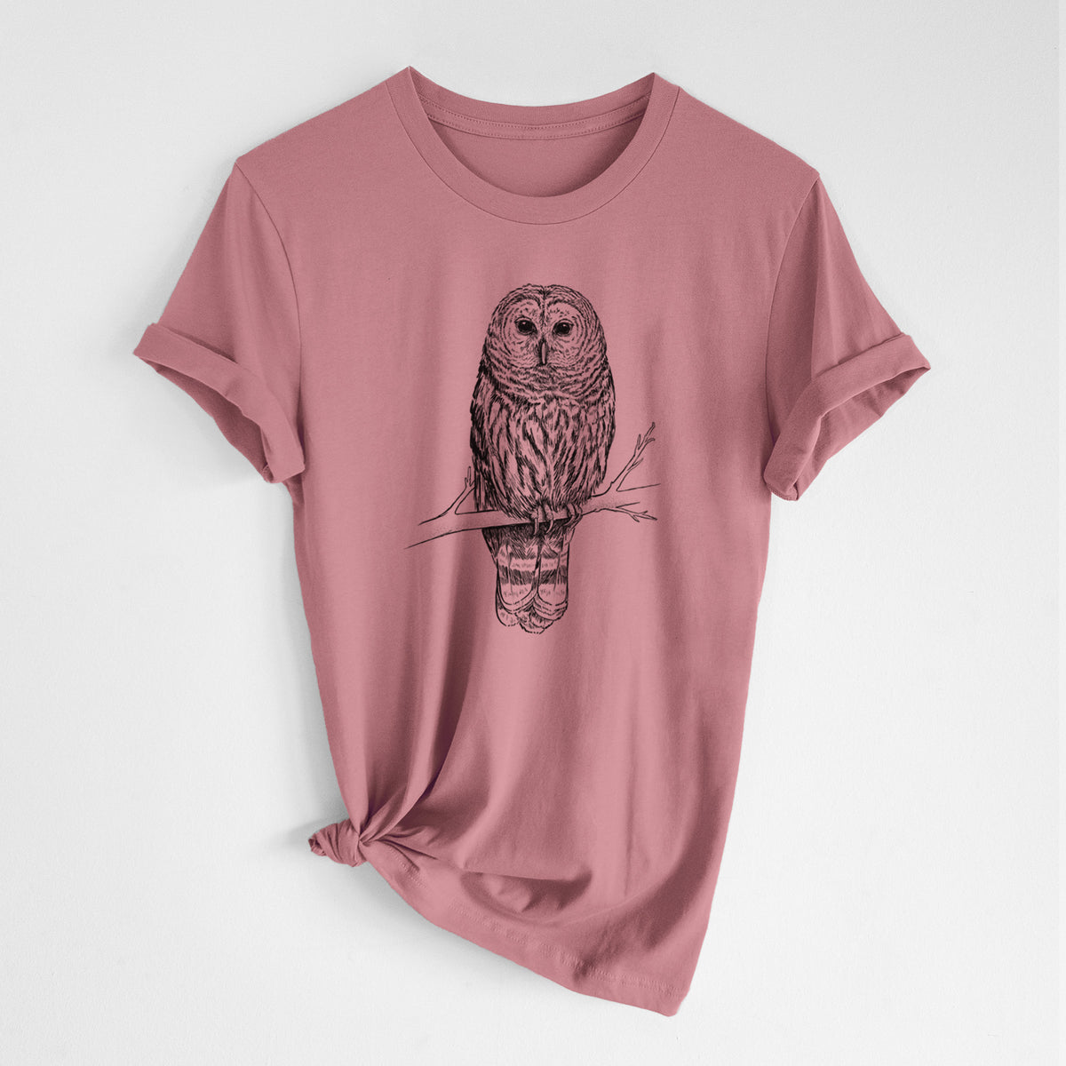 Mauve pink lightweight cotton t-shirt laid flat with the sleeves rolled, printed with a detailed black ink illustration of a barred owl perched on a branch.