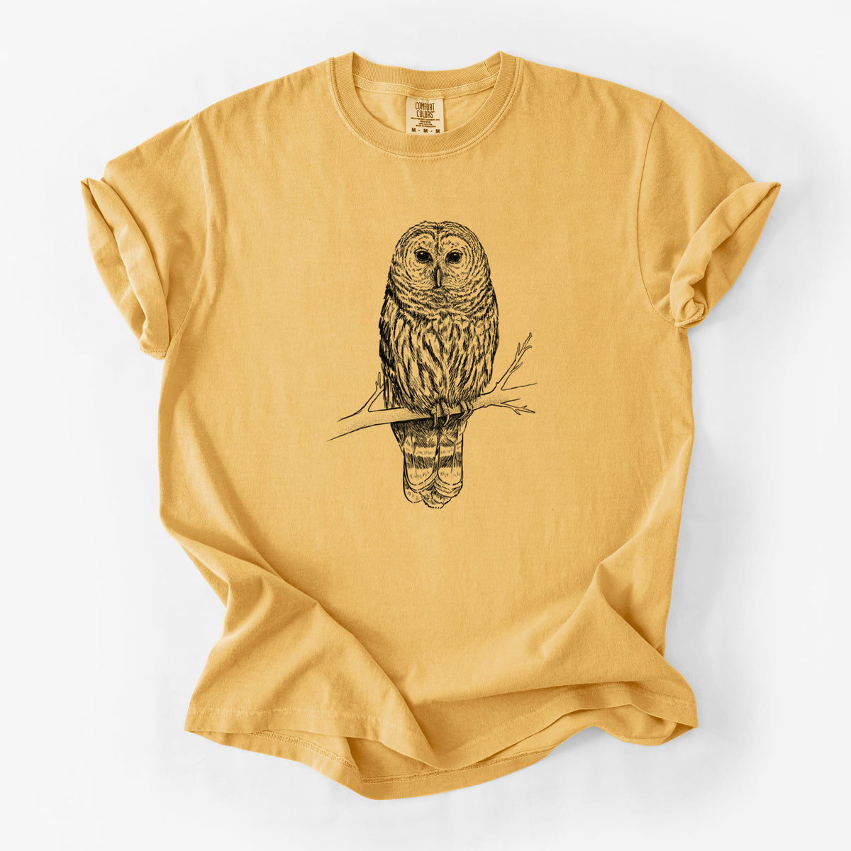 Golden wheat yellow Comfort Colors t-shirt laid flat, printed with a detailed black ink illustration of a barred owl perched on a branch.