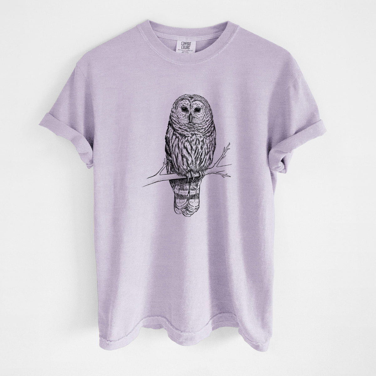 Orchid purple Comfort Colors t-shirt laid flat, printed with a detailed black ink illustration of a barred owl perched on a branch.