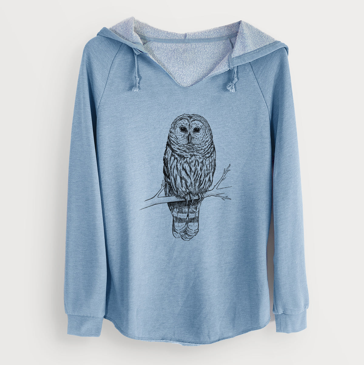 Misty blue women's Cali Wave hooded sweatshirt laid flat, printed with a detailed black ink illustration of a barred owl perched on a branch.