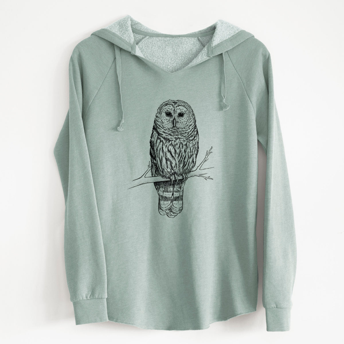 Sage green women's Cali Wave hooded sweatshirt laid flat, printed with a detailed black ink illustration of a barred owl perched on a branch.