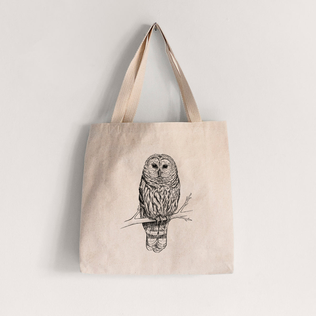 Natural canvas tote bag printed with a detailed black ink illustration of a barred owl perched on a branch.