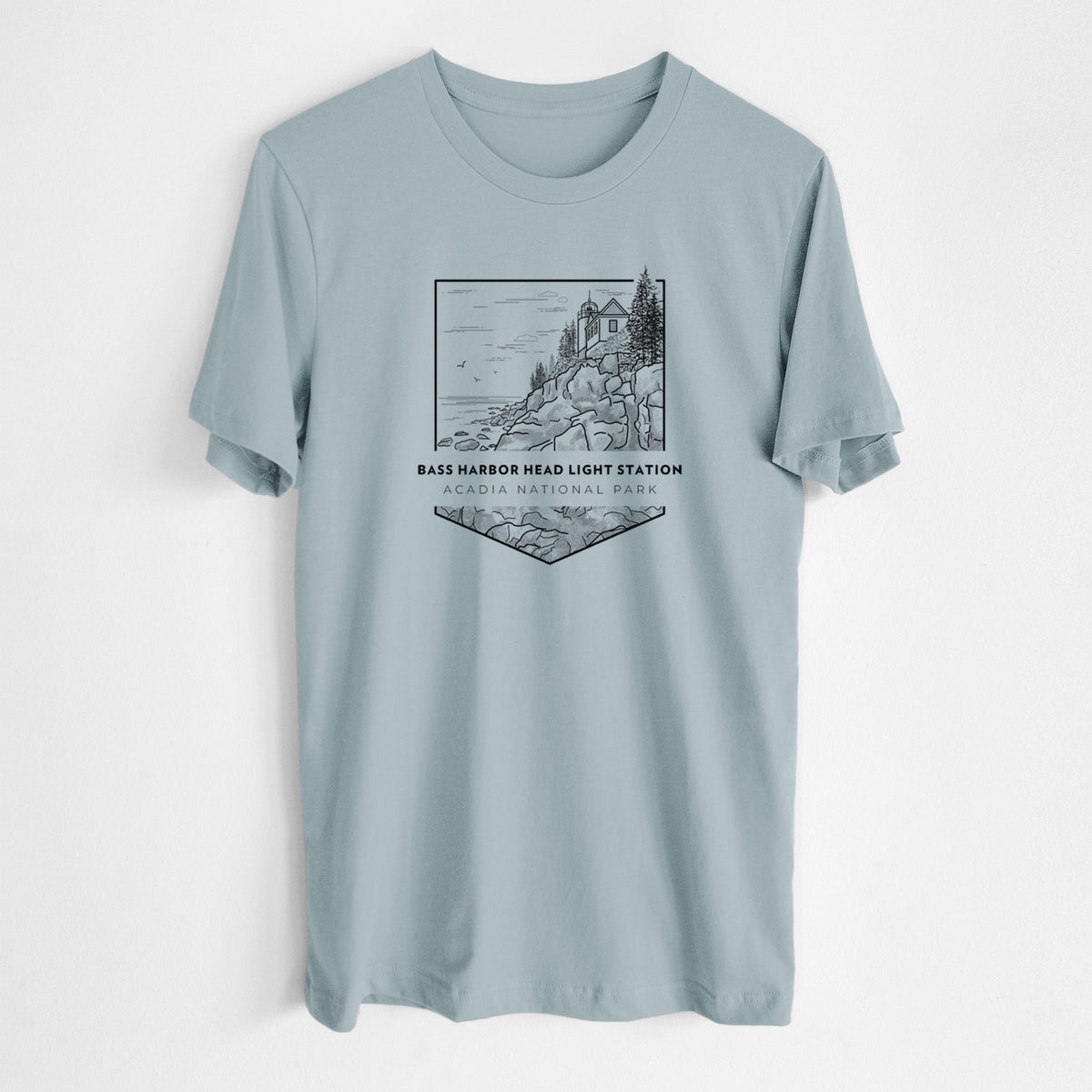 Vintage denim lightweight cotton t-shirt laid flat, printed with a black line art badge of Bass Harbor Head Light Station on a rocky cliff, with the words Acadia National Park.