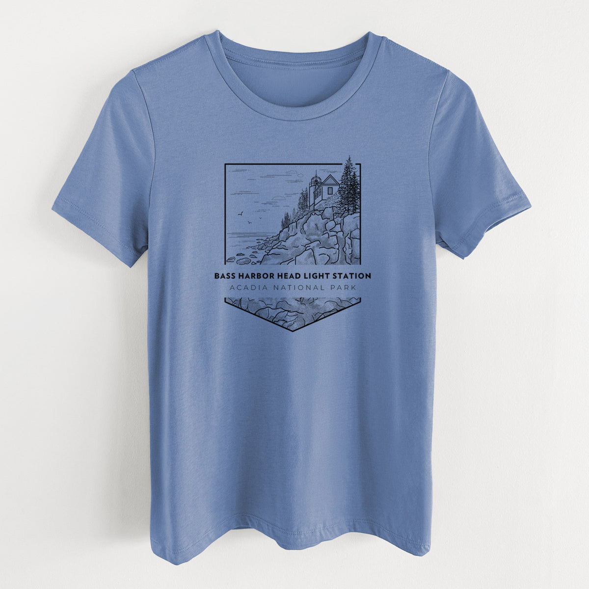 Blue bell women's relaxed fit cotton t-shirt laid flat, printed with a black line art badge of Bass Harbor Head Light Station on a rocky cliff, with the words Acadia National Park.