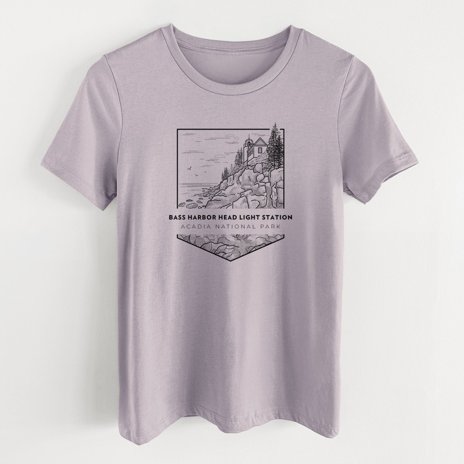 Light violet women's relaxed fit cotton t-shirt laid flat, printed with a black line art badge of Bass Harbor Head Light Station on a rocky cliff, with the words Acadia National Park.