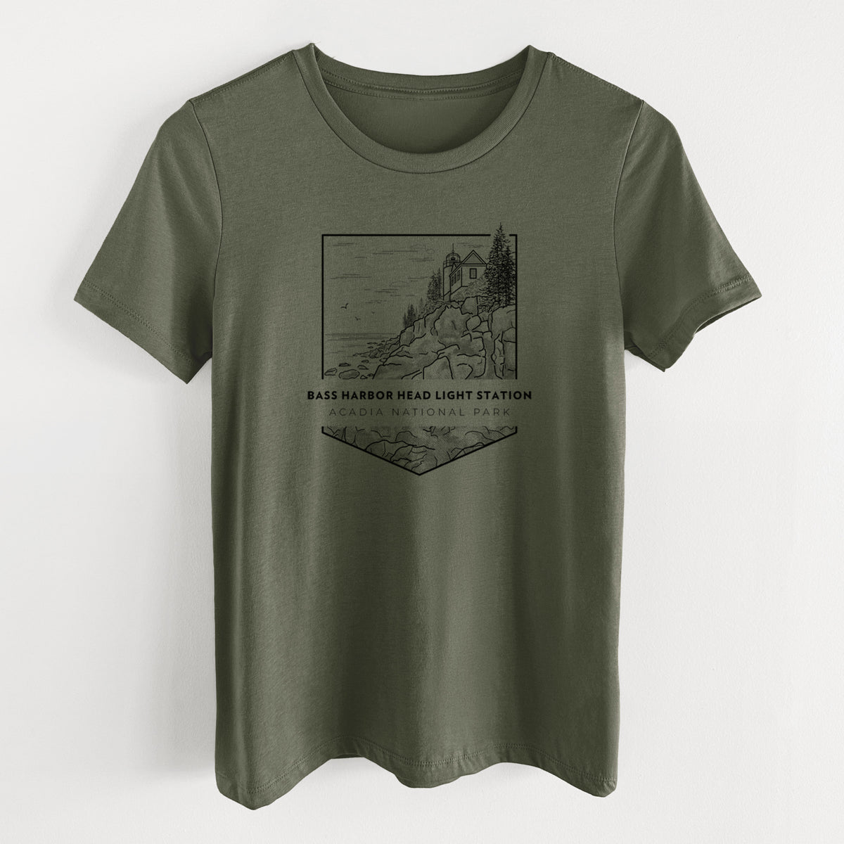 Military green women's relaxed fit cotton t-shirt laid flat, printed with a black line art badge of Bass Harbor Head Light Station on a rocky cliff, with the words Acadia National Park.