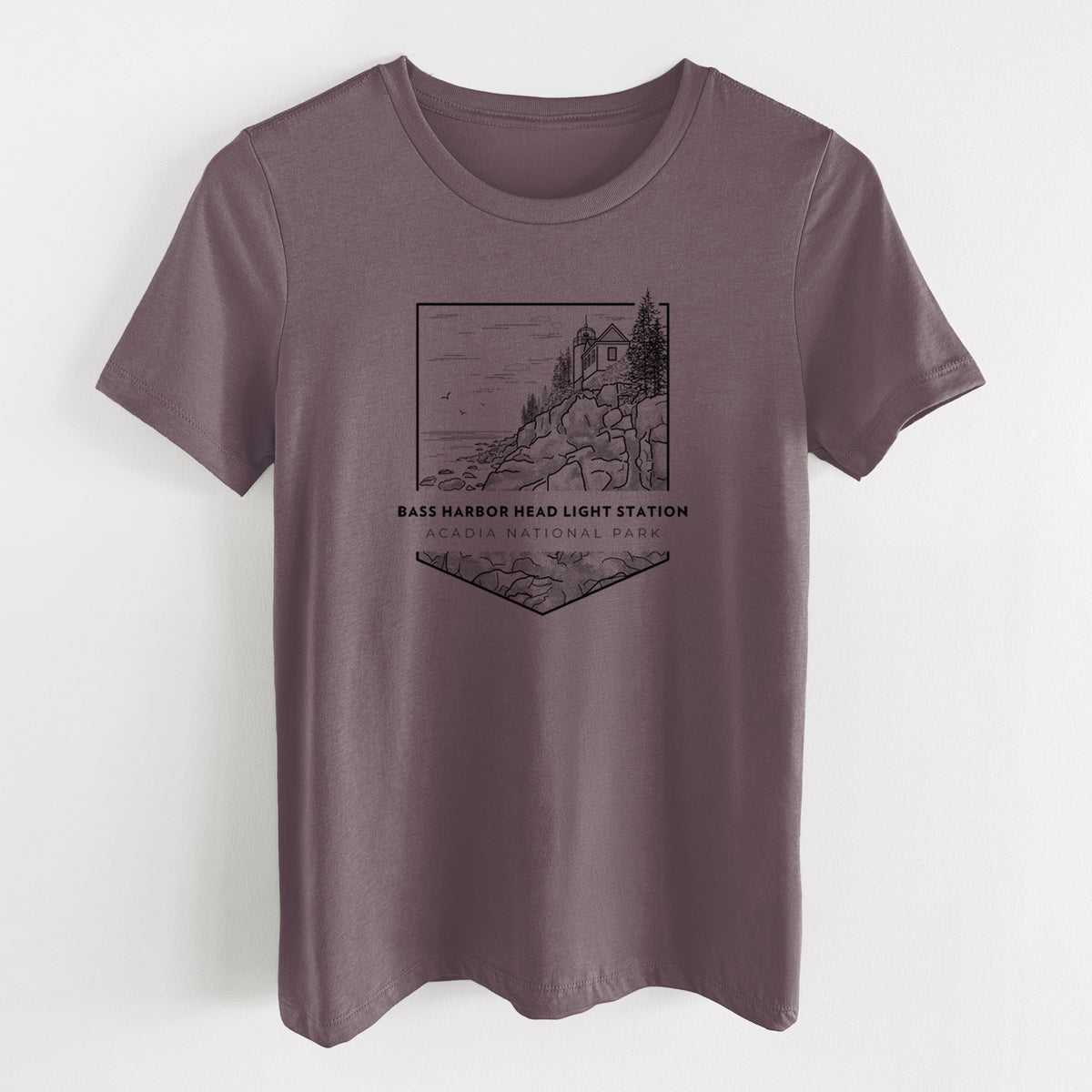 Purple storm women's relaxed fit cotton t-shirt laid flat, printed with a black line art badge of Bass Harbor Head Light Station on a rocky cliff, with the words Acadia National Park.