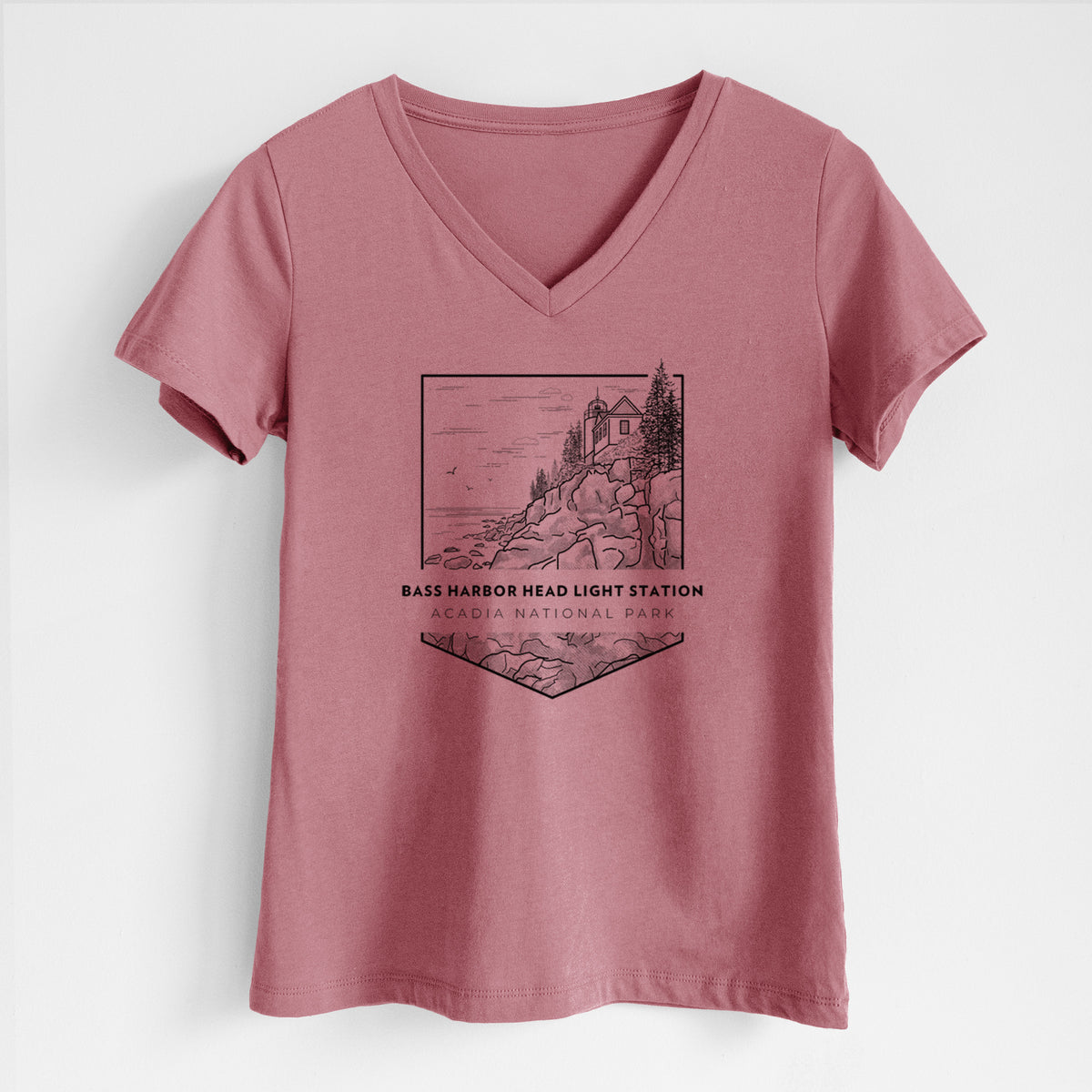 Mauve pink women's relaxed fit cotton V-neck t-shirt laid flat, printed with a black line art badge of Bass Harbor Head Light Station on a rocky cliff, with the words Acadia National Park.