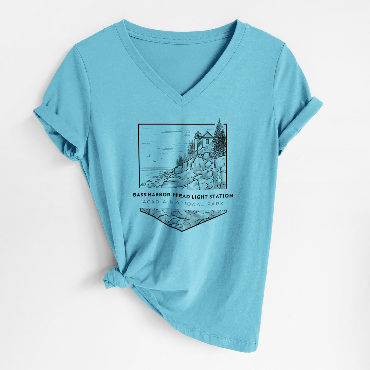 Turquoise women's relaxed fit cotton V-neck t-shirt laid flat, printed with a black line art badge of Bass Harbor Head Light Station on a rocky cliff, with the words Acadia National Park.