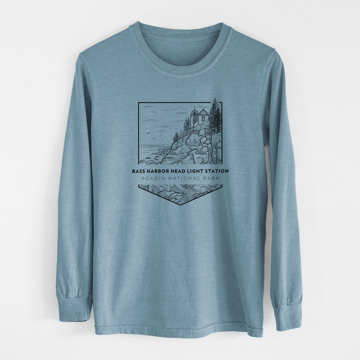 Steel blue Comfort Colors long sleeve shirt laid flat, printed with a black line art badge of Bass Harbor Head Light Station on a rocky cliff, with the words Acadia National Park.