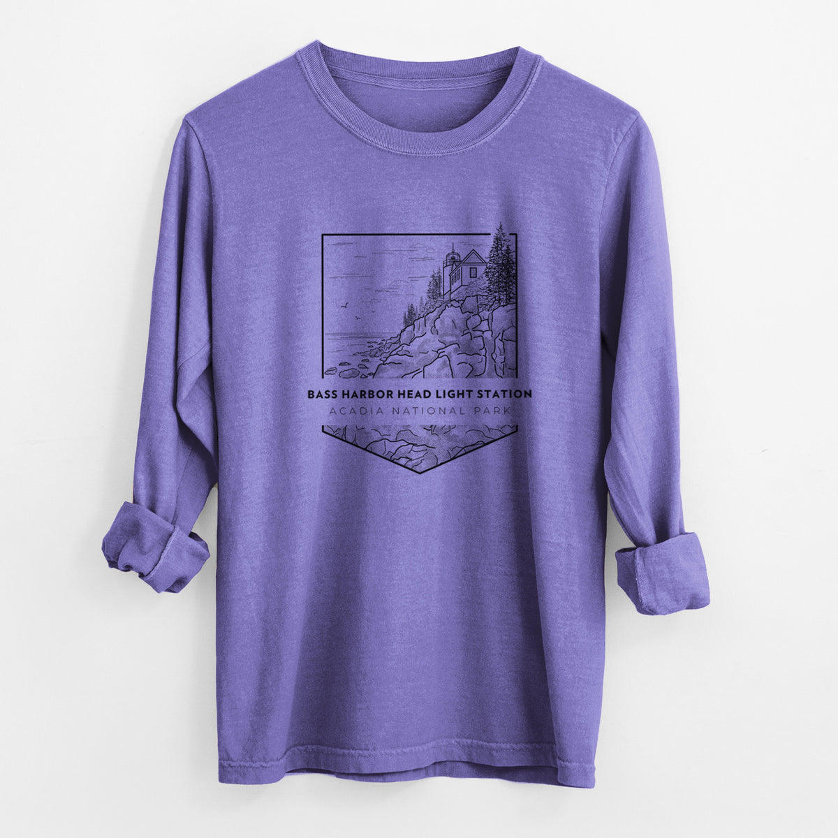 Violet purple Comfort Colors long sleeve shirt laid flat with the cuffs rolled, printed with a black line art badge of Bass Harbor Head Light Station on a rocky cliff, with the words Acadia National Park.