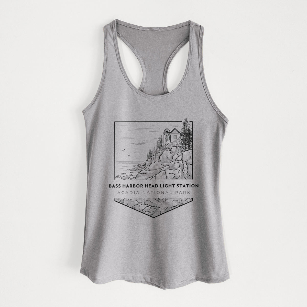 Heather grey women's racerback tank top laid flat, printed with a black line art badge of Bass Harbor Head Light Station on a rocky cliff, with the words Acadia National Park.